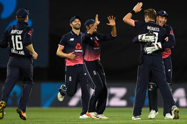 Chris Woakes celebrates with his England teammates after securing victory
