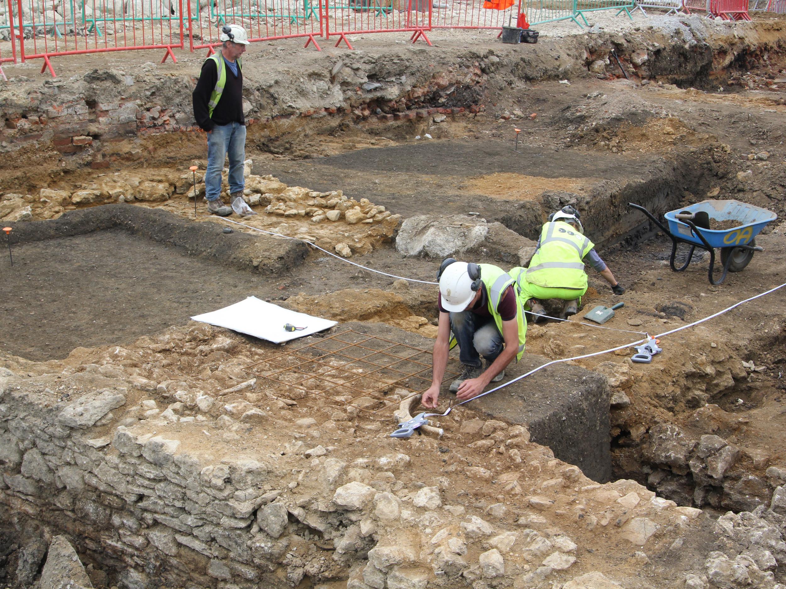 Excavating the stone lined water channel and refectory (Oxford Archaeology)