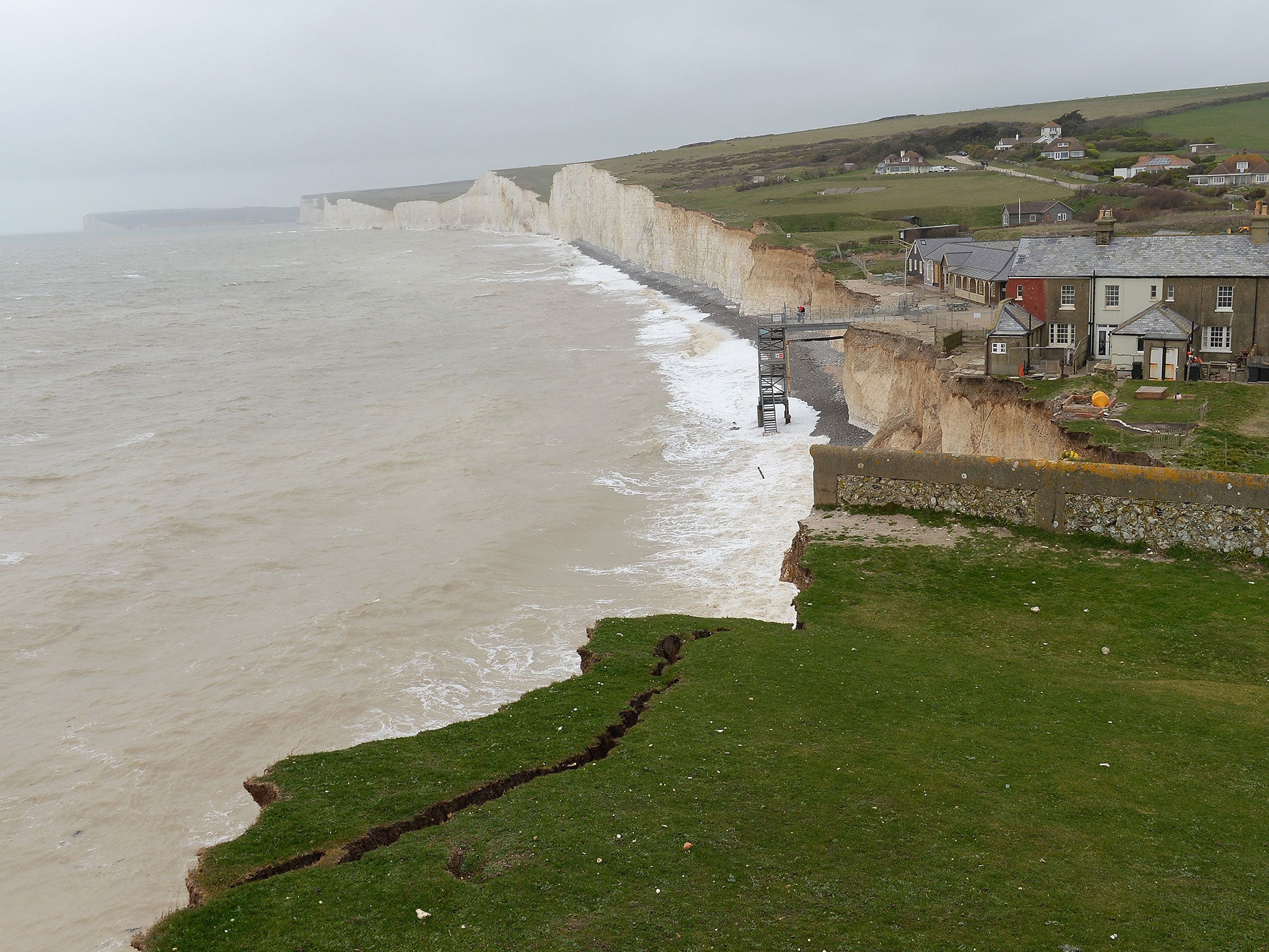 The woman's husband and two young boys were found dead at Birling Gap near Eastbourne
