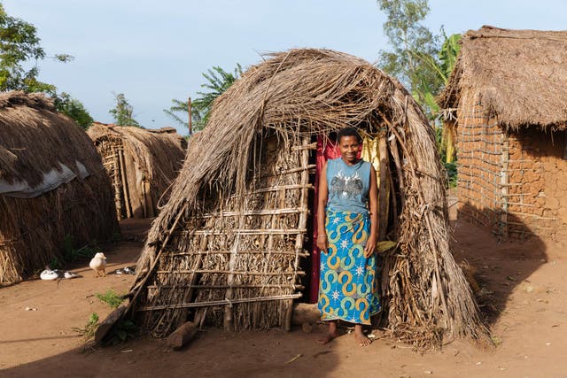 Patience standing outside her hut in the Kigyayo displacement camp in Uganda