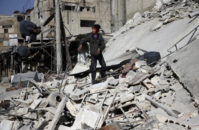 A boy stands on the rubble of a damaged building at the besieged town of Douma, eastern Ghouta on 5 March 2018