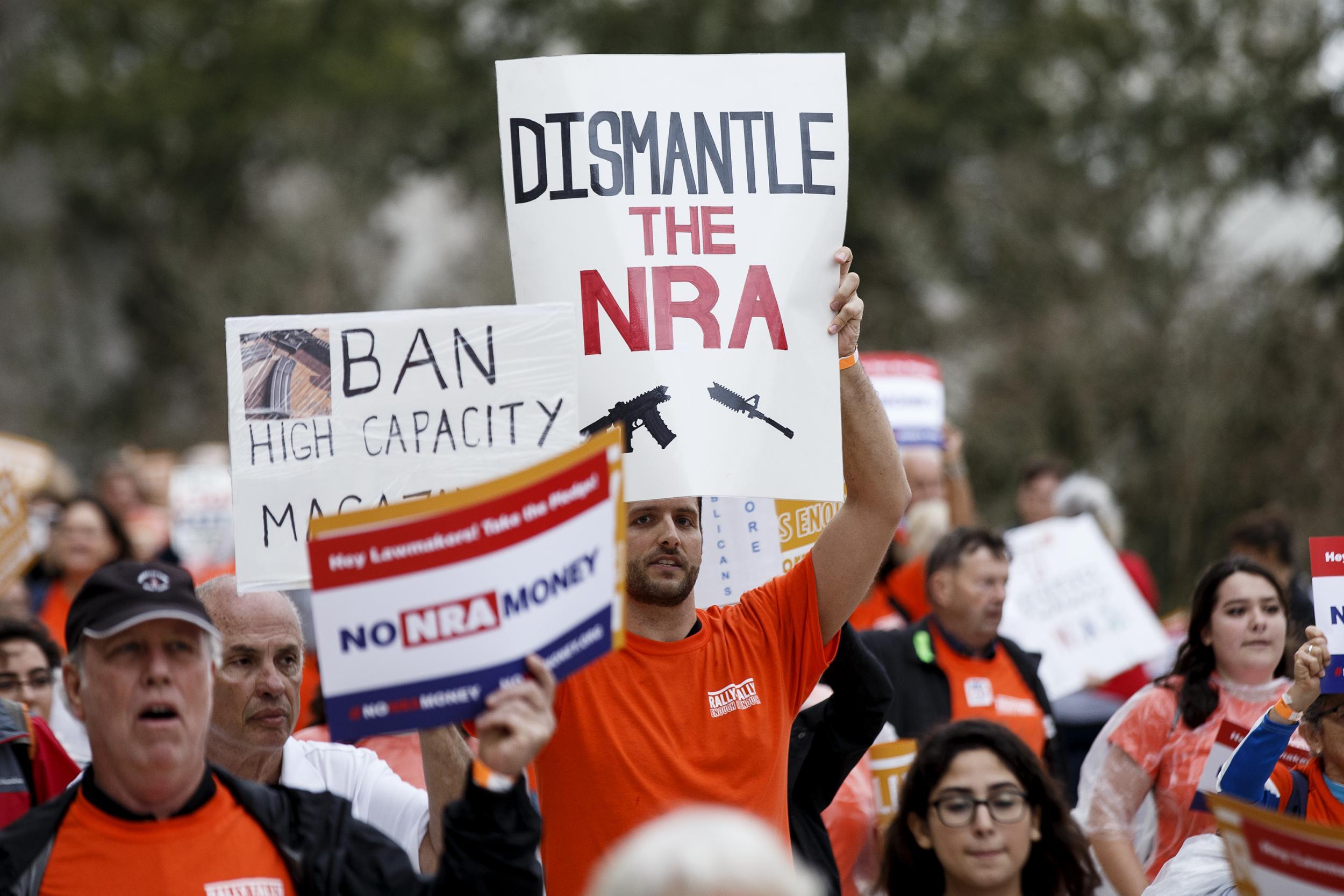 Activists hold up signs at the Florida State Capitol as they rally for gun reform legislation