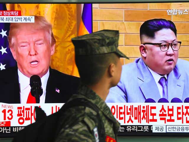 A television screen showing pictures of US President Donald Trump and North Korean leader Kim Jong-Un at a railway station in Seoul