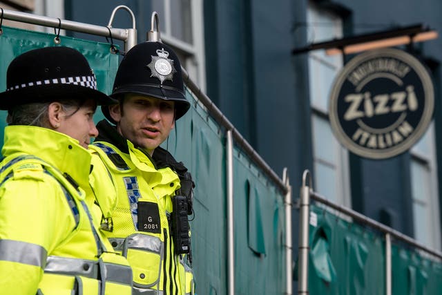 Police officers stand outside Zizzi restaurant as it remains closed as investigations continue into the poisoning of Sergei Skripal