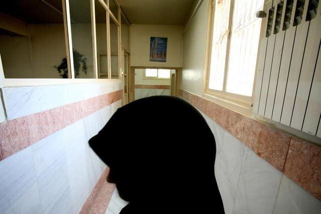 A female prison guard stands along a corridor in Tehran's Evin prison