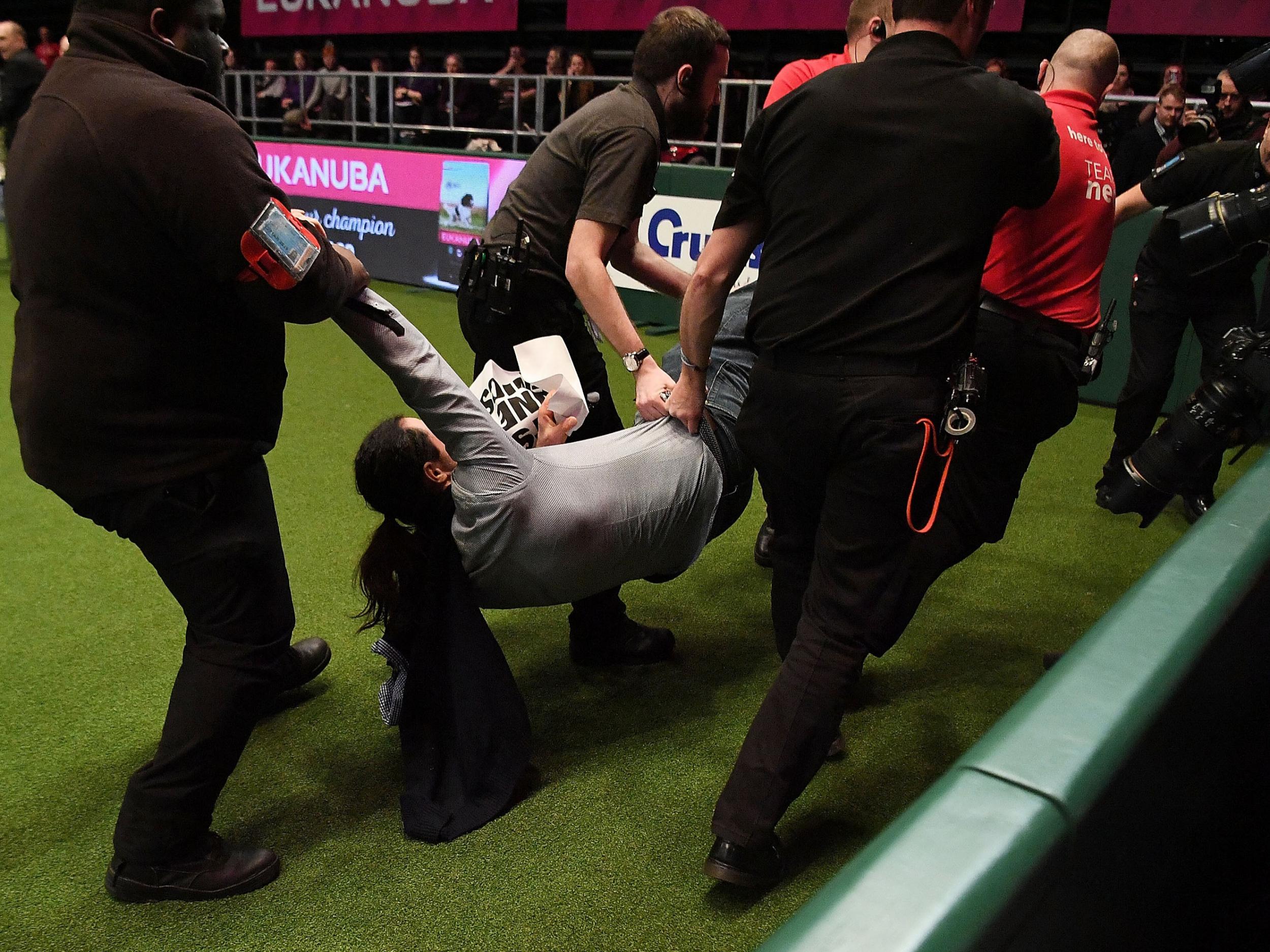 A protester is carried off after running into the Crufts arena