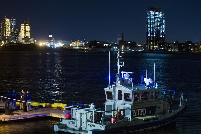 Yellow buoys that a New York police officer said are suspending the helicopter that crashed on the East River float next to a NYPD police boat.