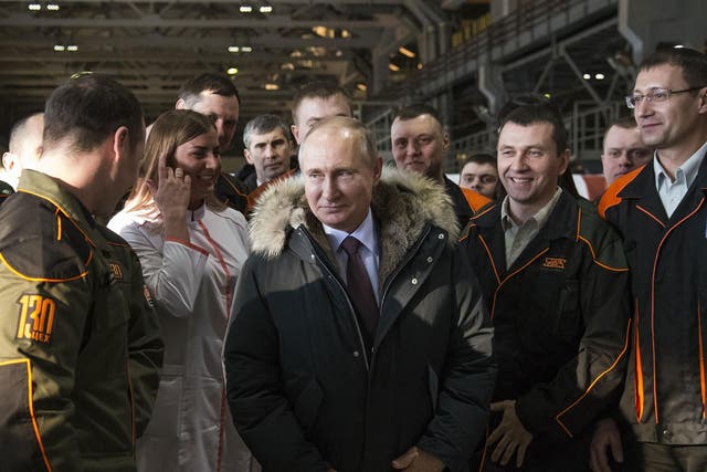 Putin listens to employees of at a factory in Nizhny Tagil.