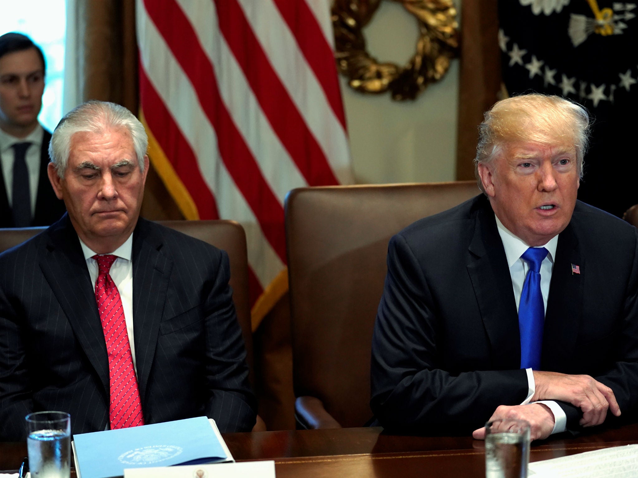 Mr Tillerson pictured seated beside Mr Trump at the White house