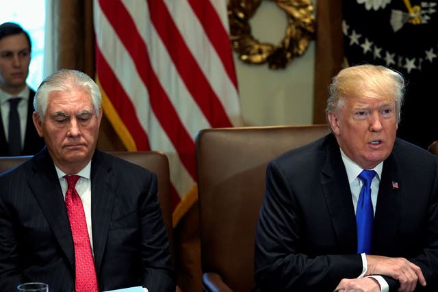 Mr Tillerson pictured seated beside Mr Trump at the White house