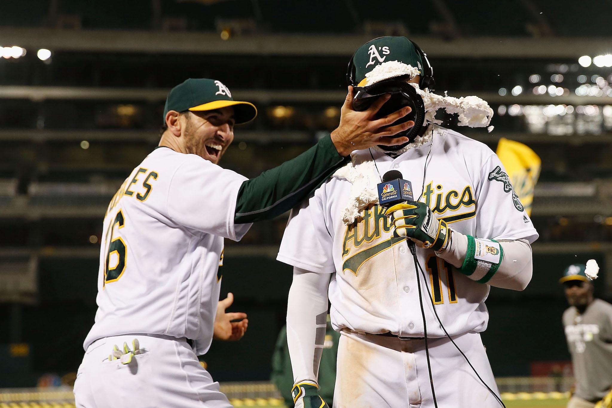 Rajai Davis #11 of the Oakland Athletics is hit with a pie by teammate Adam Rosales #16 of the Oakland Athletics after Davis hit a two-run walk-off home run in the 9th inning against the Minnesota Twins at Oakland Alameda Coliseum