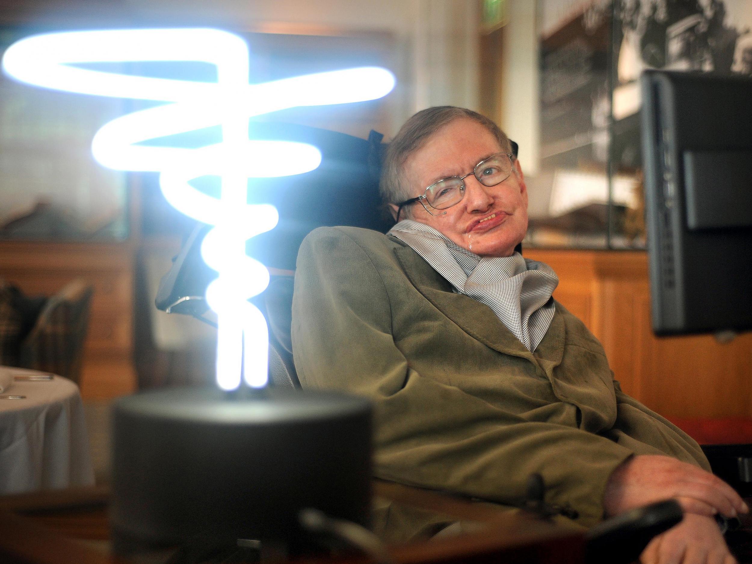 Professor Hawking posing beside a lamp titled 'black hole light' by inventor Mark Champkins, presented to him during a visit to London's Science Museum in 2012