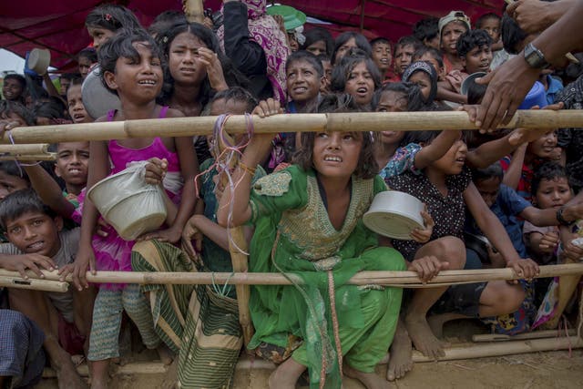 Rohingya Muslim children wait for food handouts distributed by a Turkish aid agency at Thaingkhali refugee camp in Bangladesh