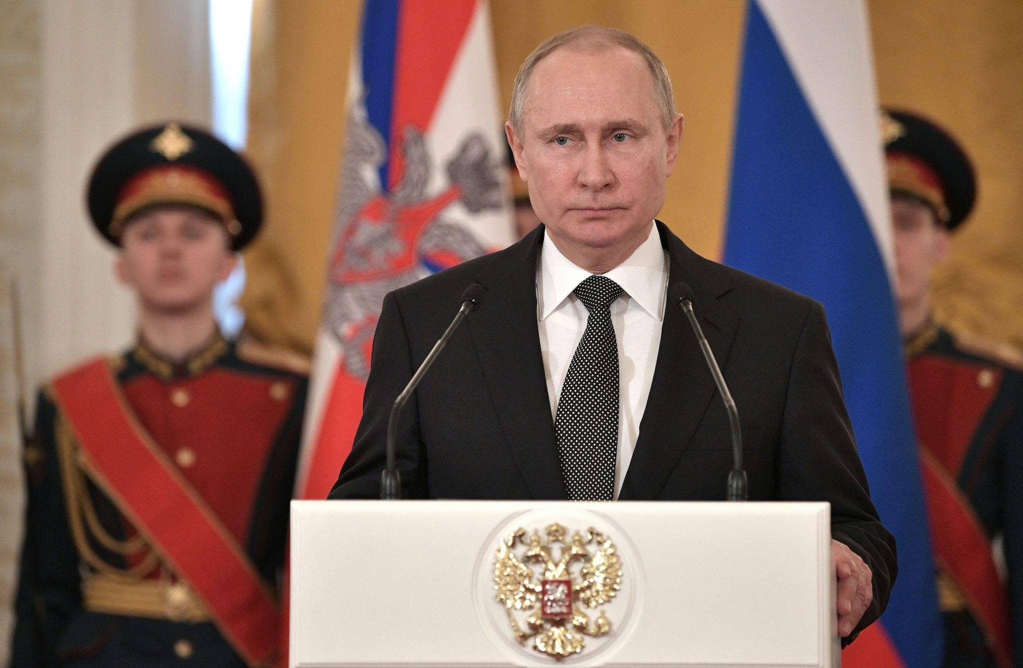 Russian President Vladimir Putin (C) delivers a speech during a ceremony to present national award and to mark the Defender of the Fatherland Day at the Kremlin