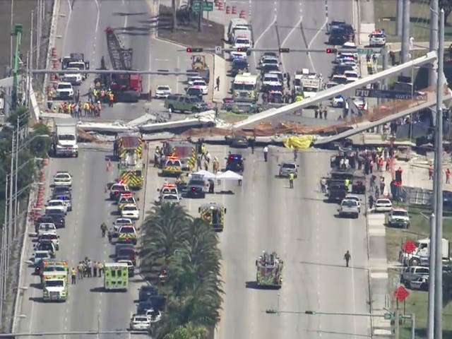 Emergency personnel work at the scene of a collapsed bridge in the Miami.