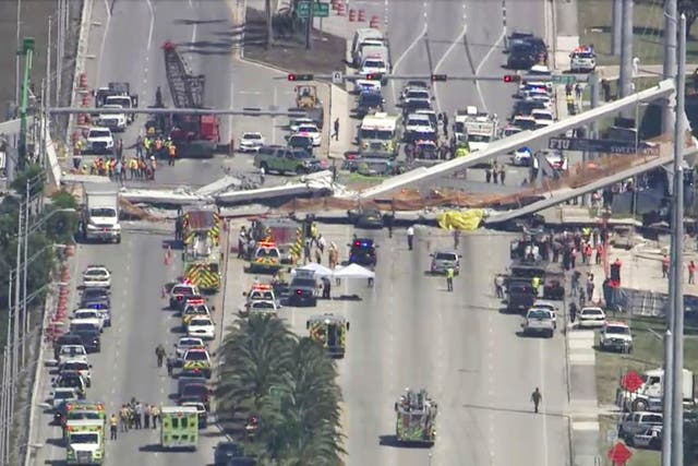 Emergency personnel work at the scene of a collapsed bridge in the Miami.