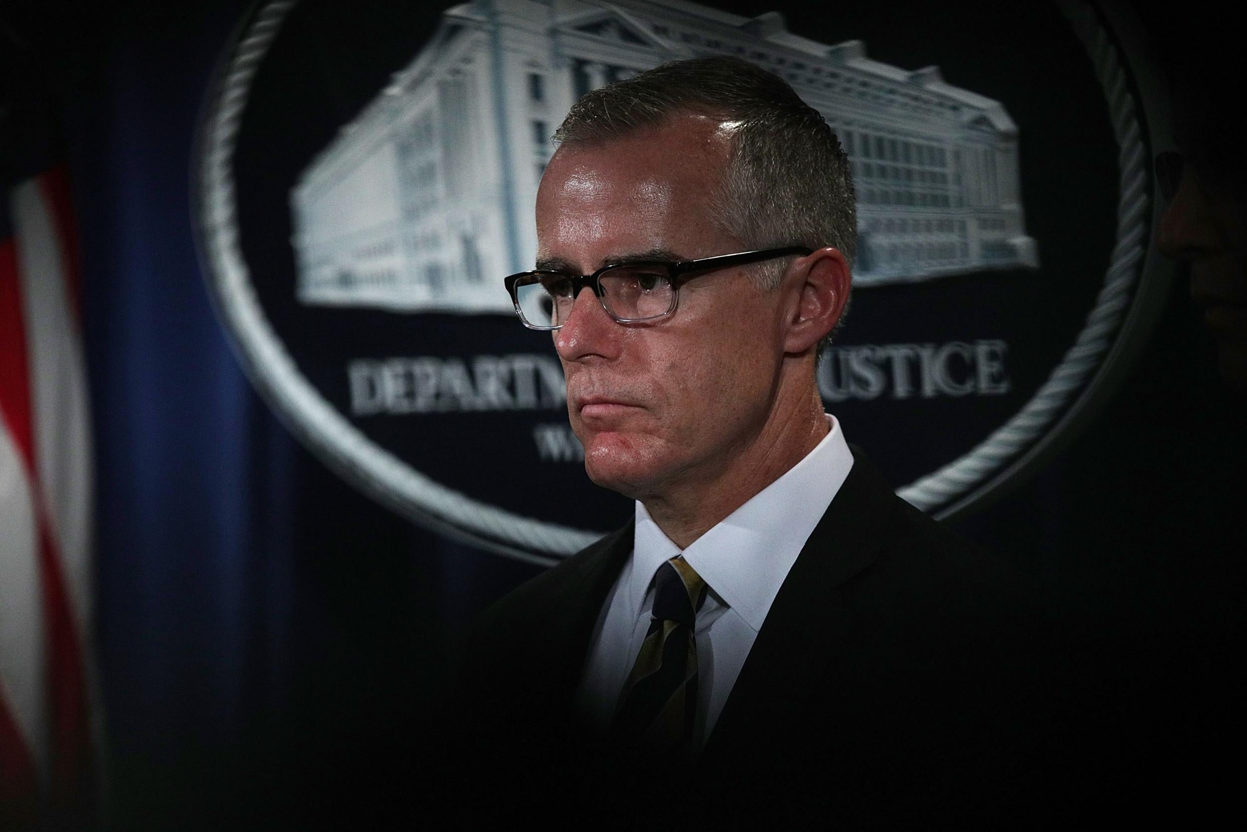 Andrew McCabe listens during a news conference to announce significant law enforcement actions