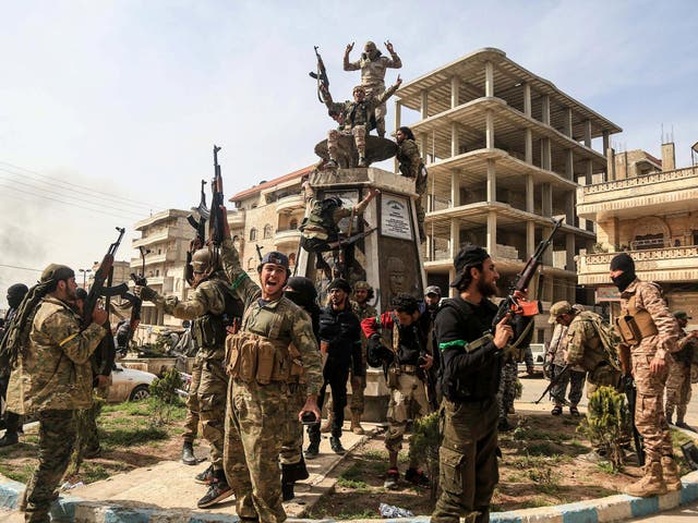 Turkish-backed Free Syrian Army soldiers celebrate after reportedly taking complete control of the city of Afrin, northern Syria