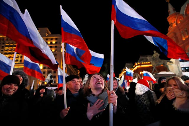 Voters wave Russian flags in Manezhnaya square, near the Kremlin in Moscow, where Valdimir Putin has won a fourth term as the country's leader