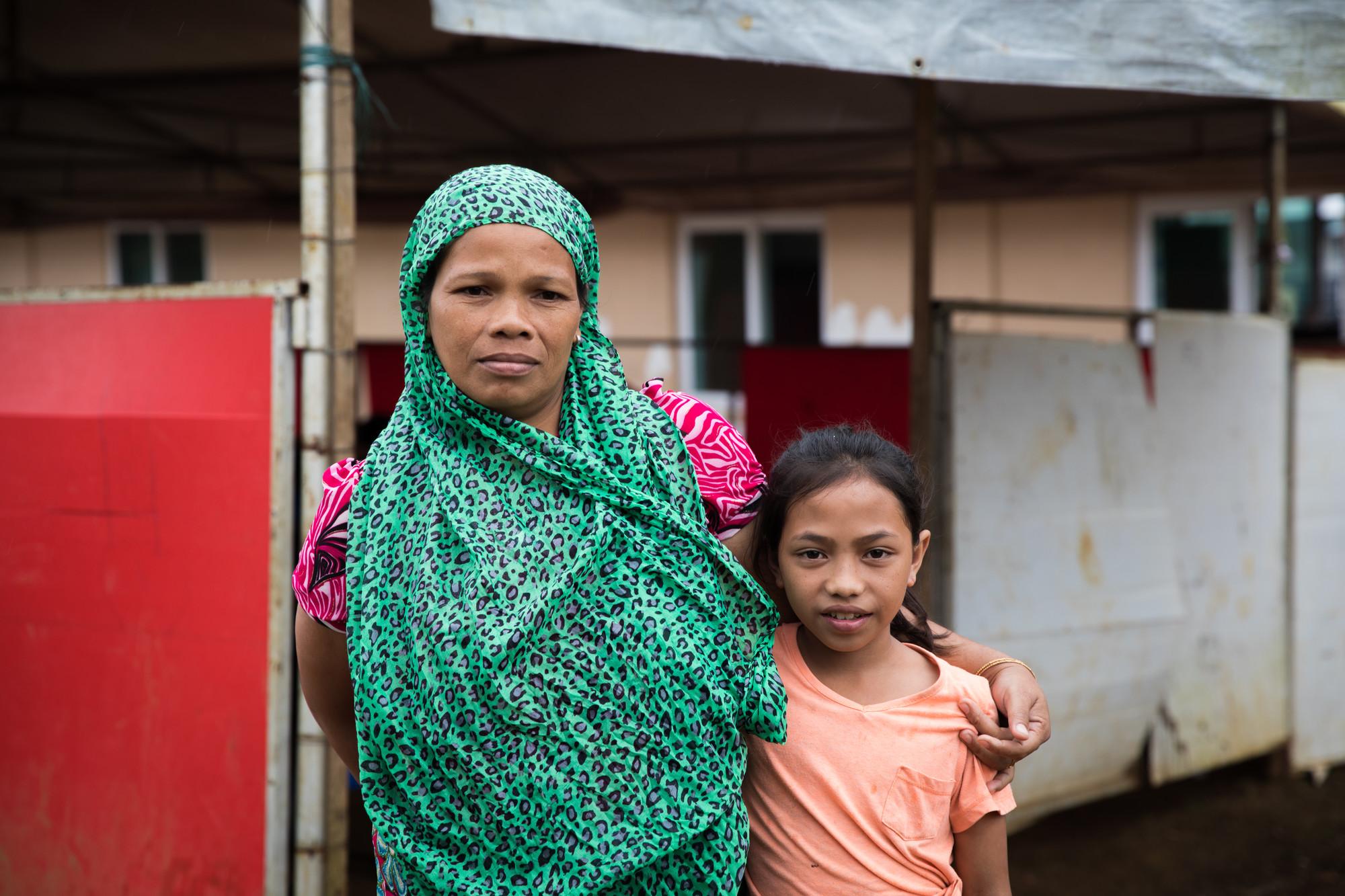 Vilma, 38, and her 10 year-old daughter Aisah stand outside a Save the Children temporary learning centre near Marawi