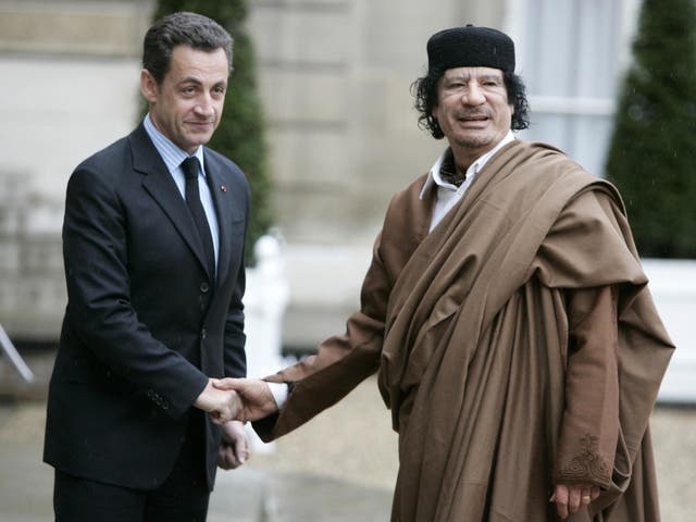 Former President Nicolas Sarkozy greets late Libyan leader Colonel Muammar Gaddafi at the Elysee Palace in Paris in 2007