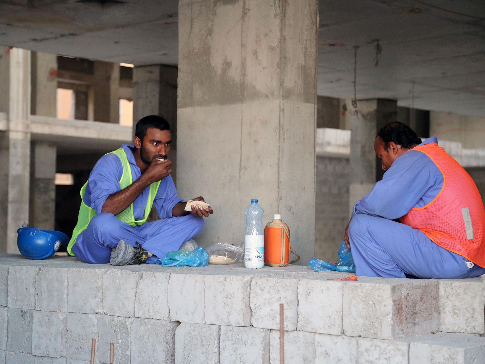 Workers take a break at a construction site in Qatar