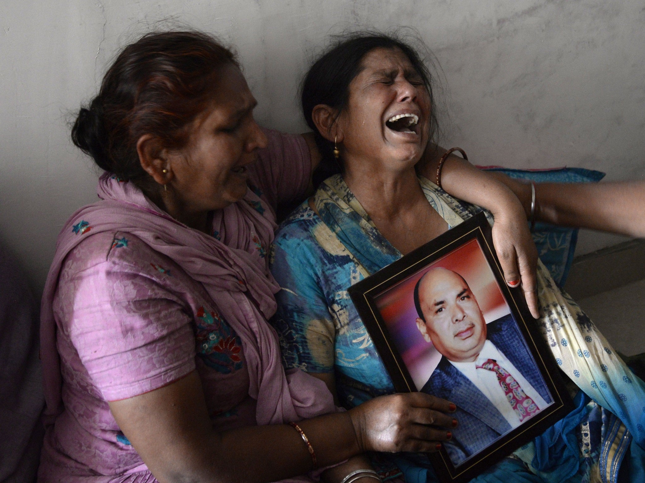 Gyan Kaur holds a photograph of her husband Balwant Rai after hearing confirmation of his death