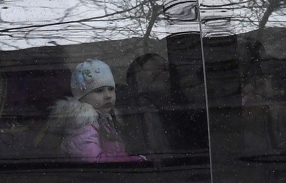 A child sits on a bus with diplomatic number plates as staff and children arrive at Russia’s Embassy in London (Reuters)