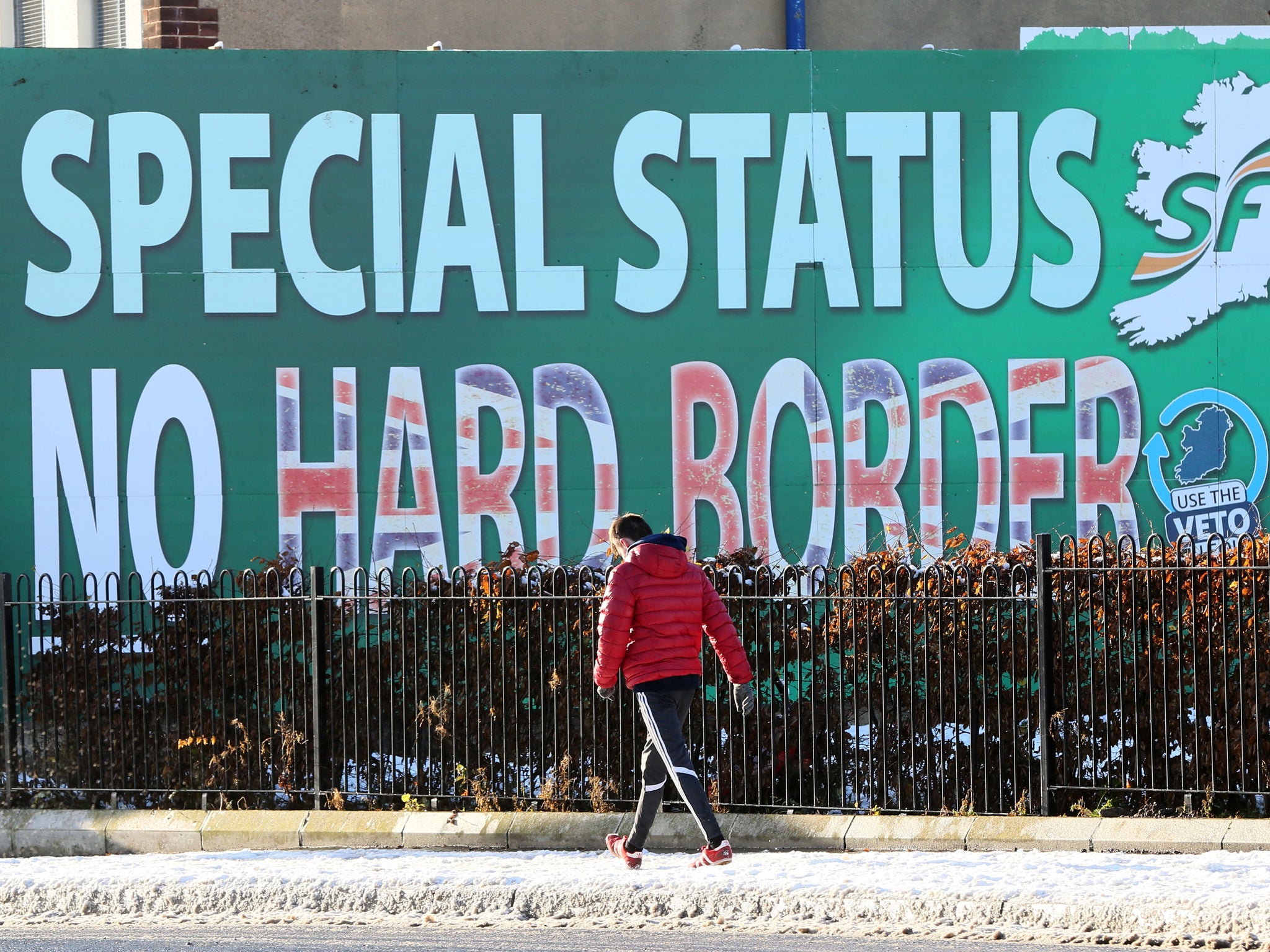 A pedestrian walks past a billboard in west Belfast