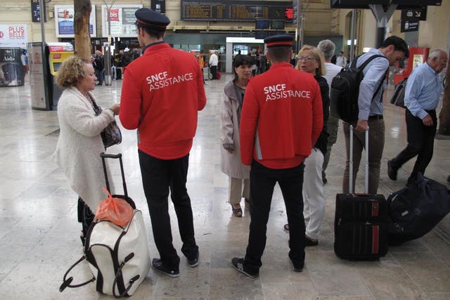 Standing by: SNCF staff help travellers on a previous strike day at Marseille St-Charles station