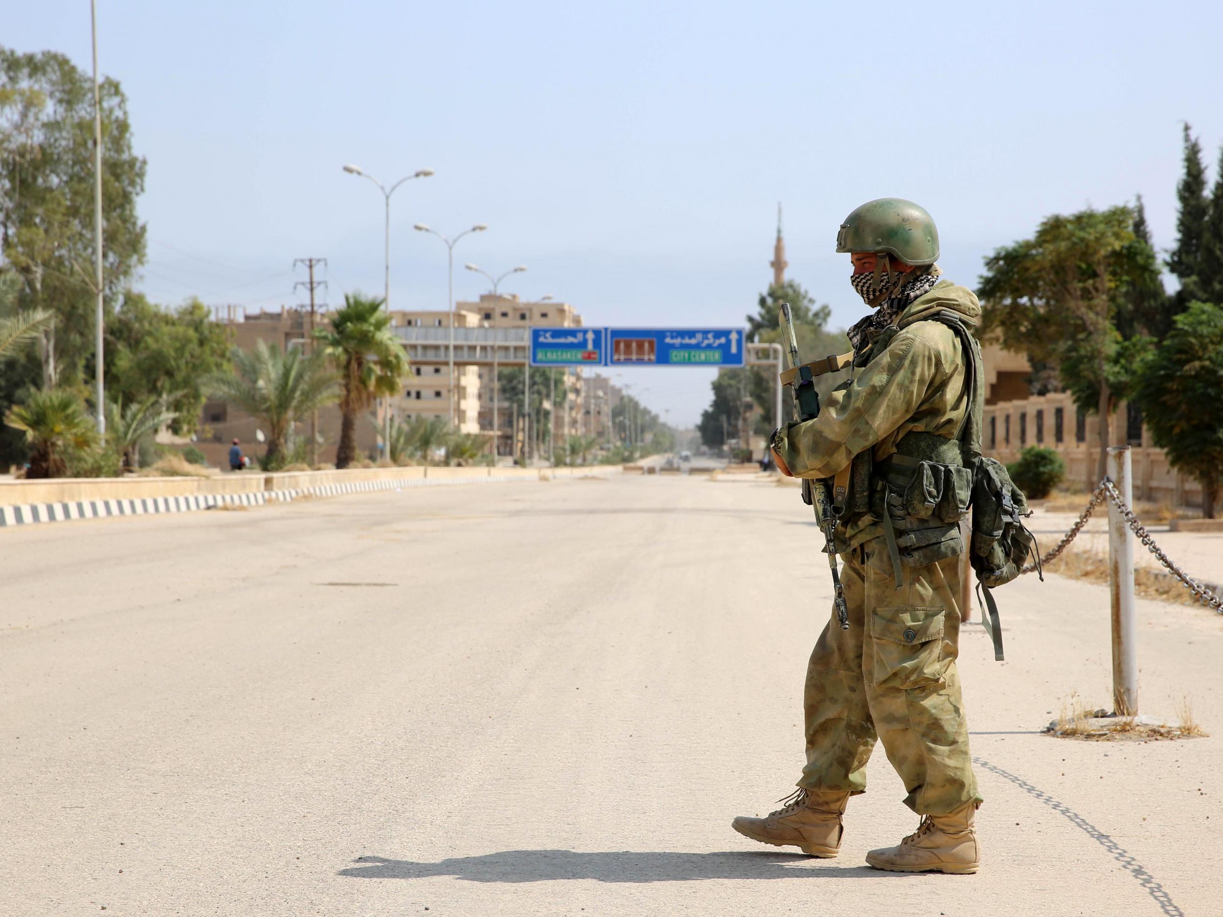 A Russian soldier stands guard in a central street in Syria's eastern city of Deir Ezzor