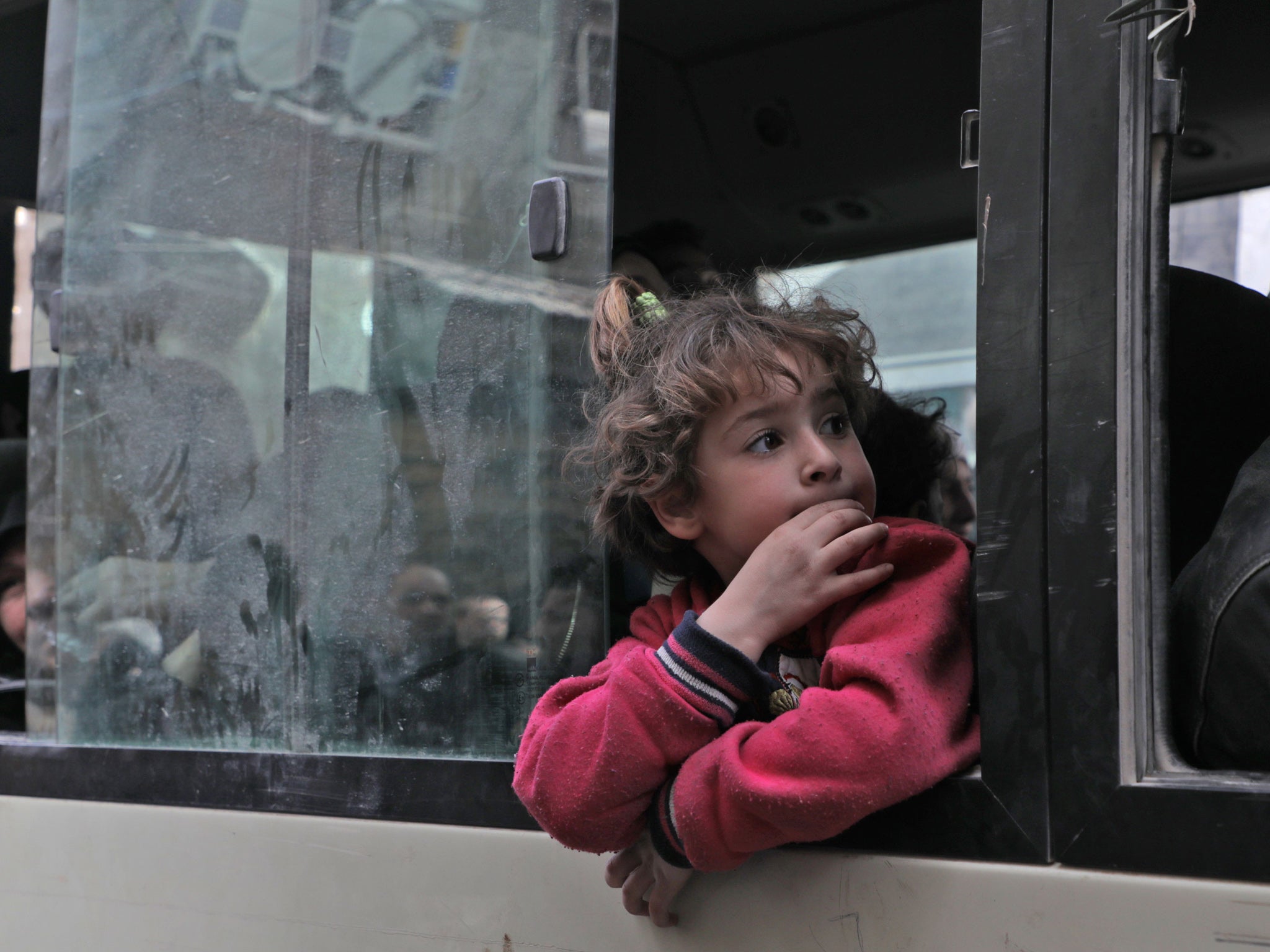 A Syrian child looks out the window of a vehicle during a civilian evacuation by the Syrian Red Crescent in the rebel-held Eastern Ghouta.