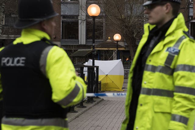 Police officers stand close to a bench in Salisbury where former Russian spy Sergei Skripal and his daughter, Yulia, were found suffering from extreme exposure to a rare nerve agent