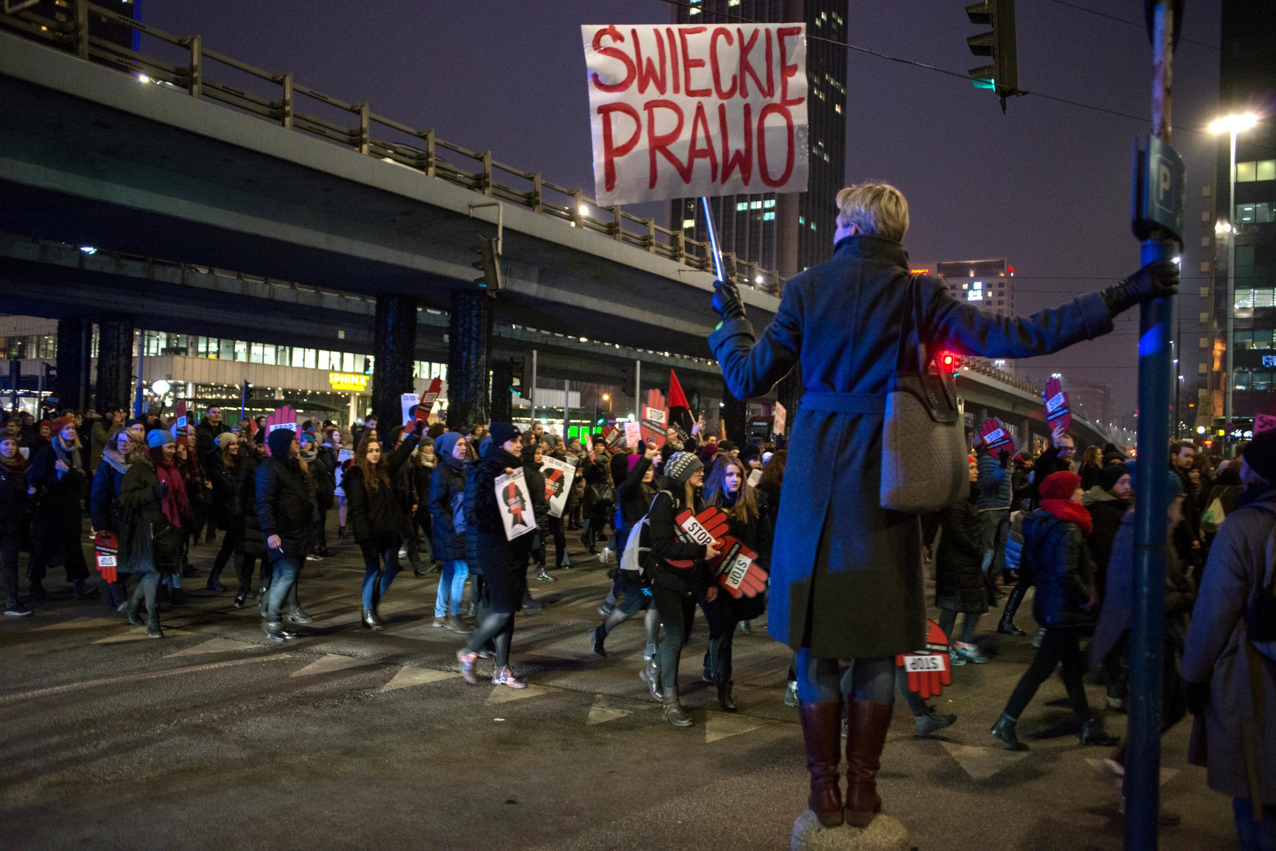 A woman holds up a banner reading 'secular law’