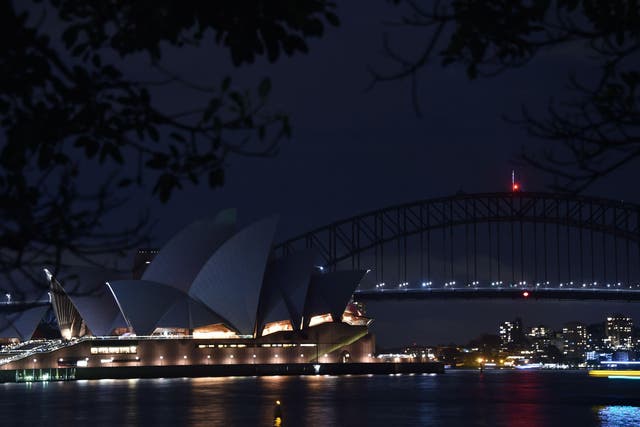 Sydney Harbour Bridge and the Opera House are plunged into darkness for the Earth Hour environmental campaign on March 24, 2018.