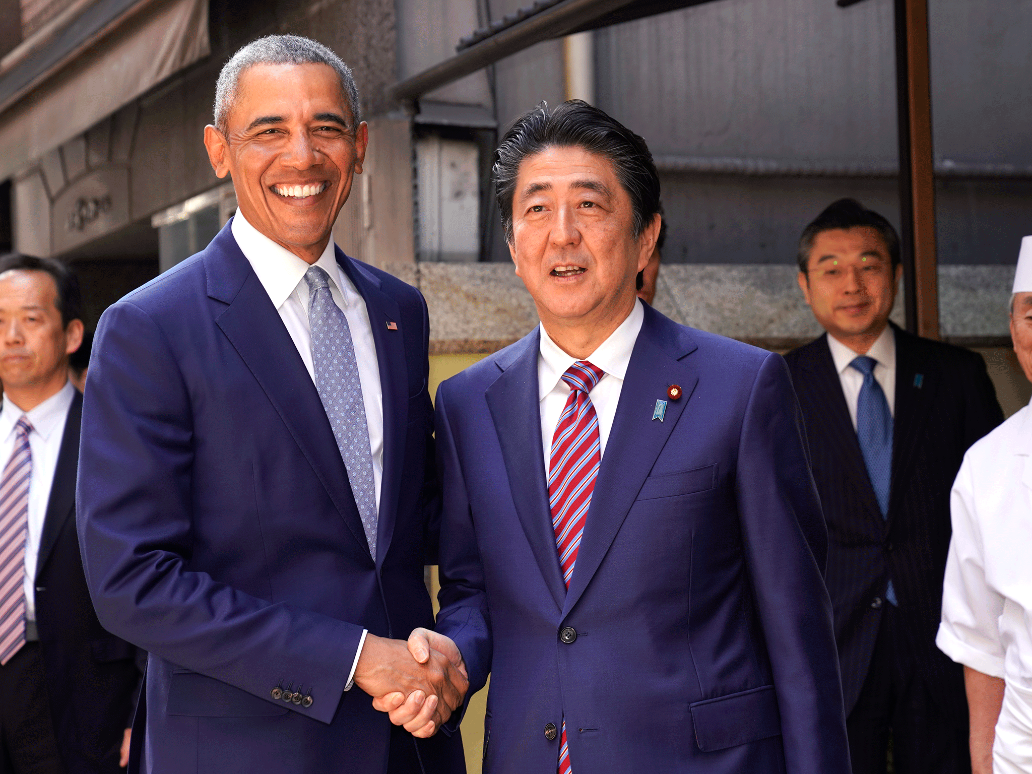 Barack Obama and Japanese Prime Minister Shinzo Abe pose for photographers in front of Japanese Sushi restaurant in Tokyo's Ginza shopping district