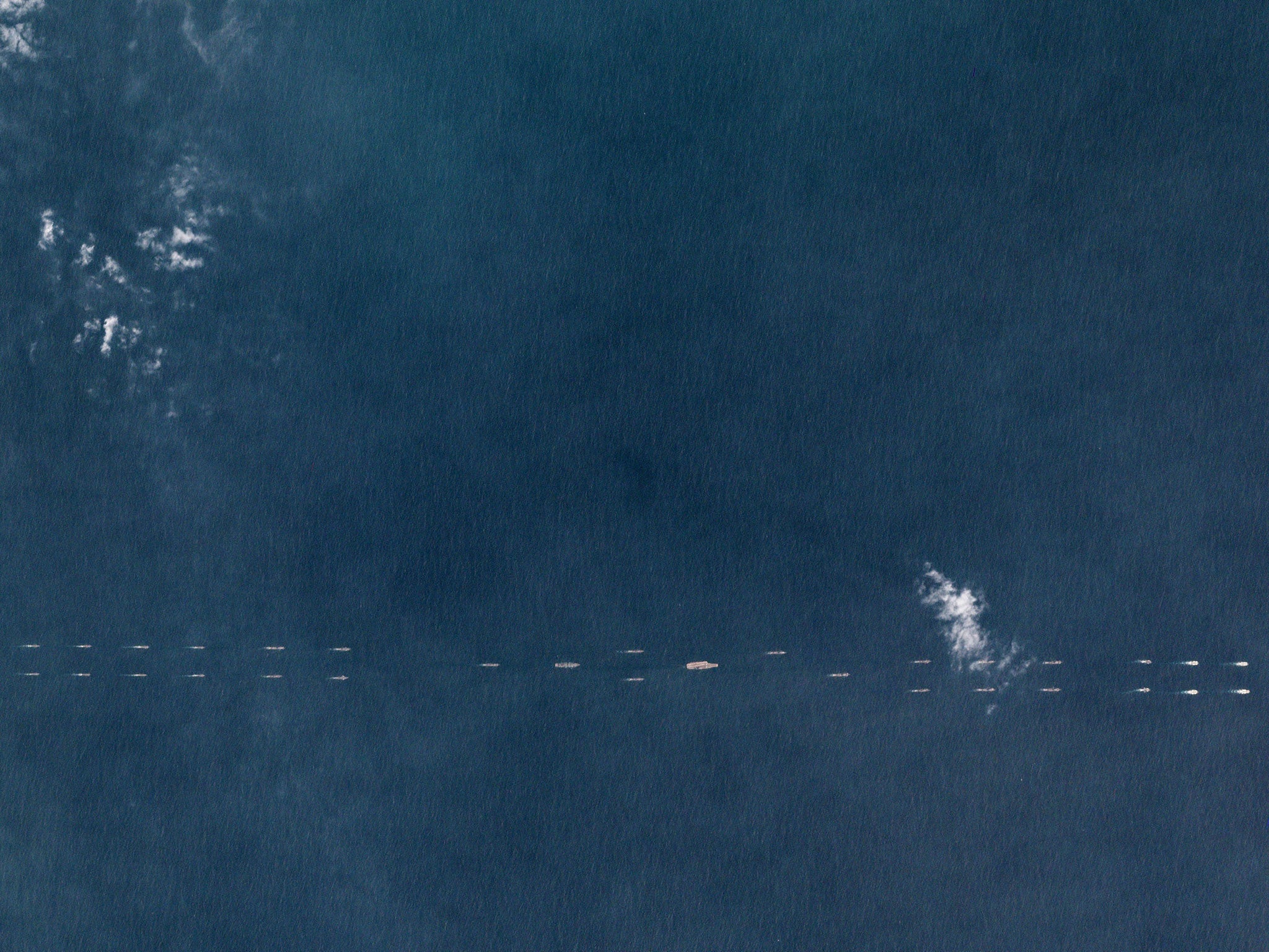 Satellite images show what appear to be at least 40 ships and submarines flanking the carrier, 'Liaoning', supported by aircraft above