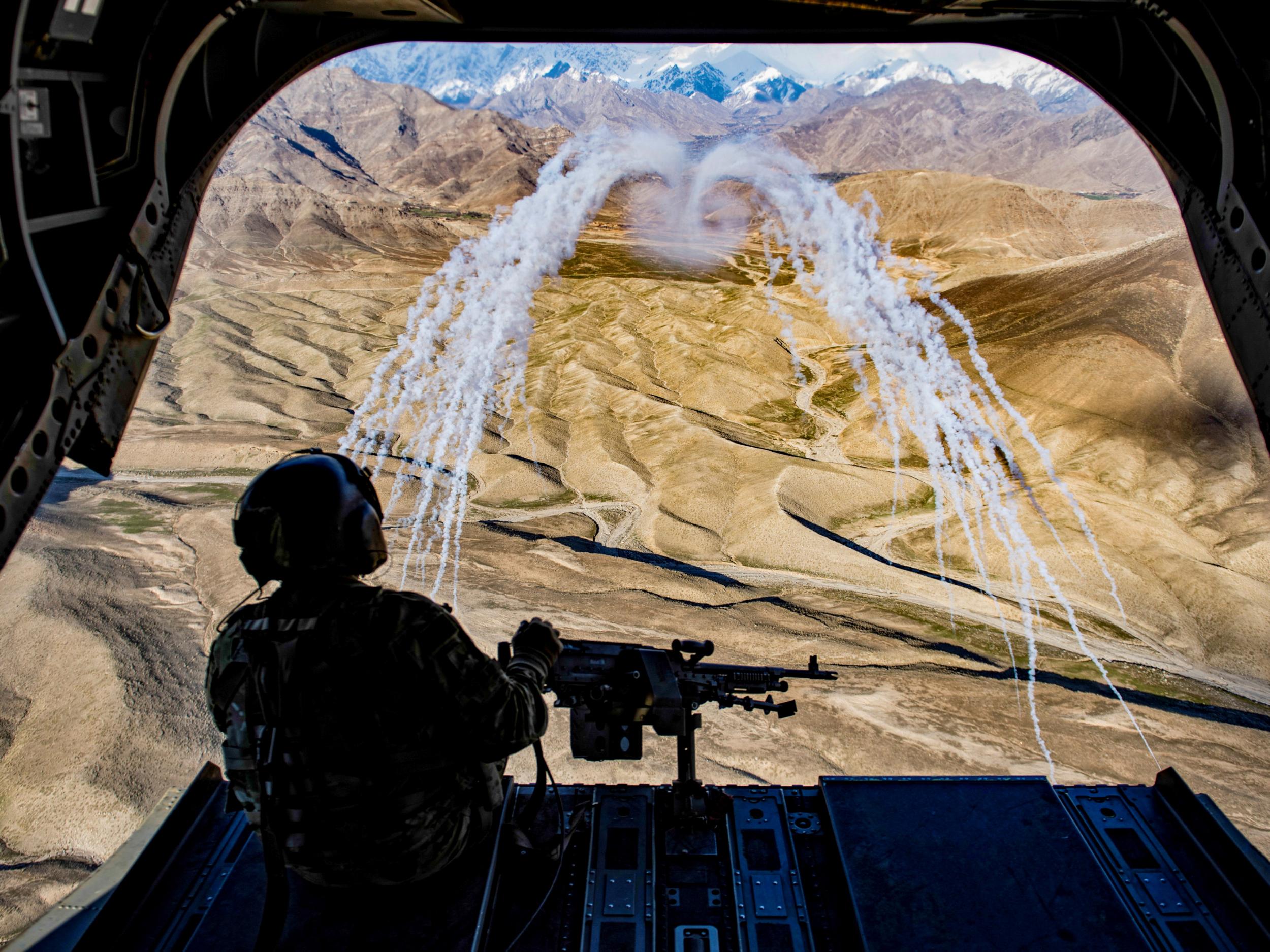 A U.S. Army crew chief flying on board a CH-47F Chinook helicopter observes the successful test of flares during a training flight in Afghanistan