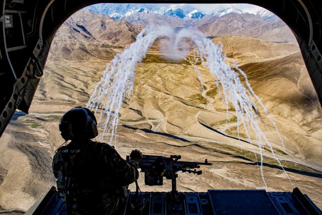 A U.S. Army crew chief flying on board a CH-47F Chinook helicopter observes the successful test of flares during a training flight in Afghanistan