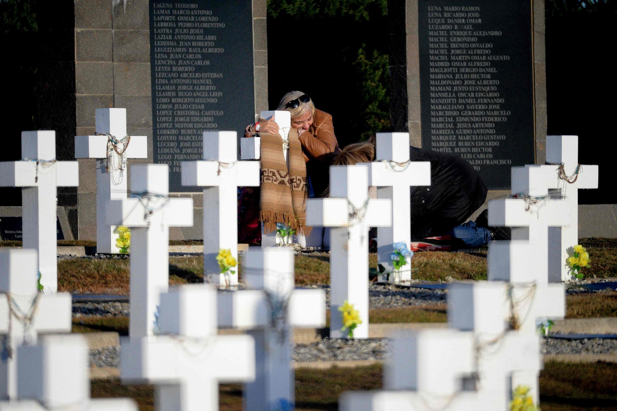 Relatives of an Argentine soldier killed during Falklands War embrace at Darwin Cemetery