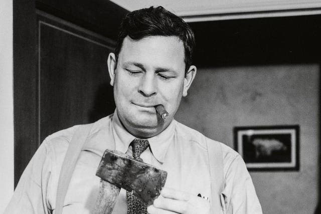 A cigar-chomping detective examines the murder weapon, 1940