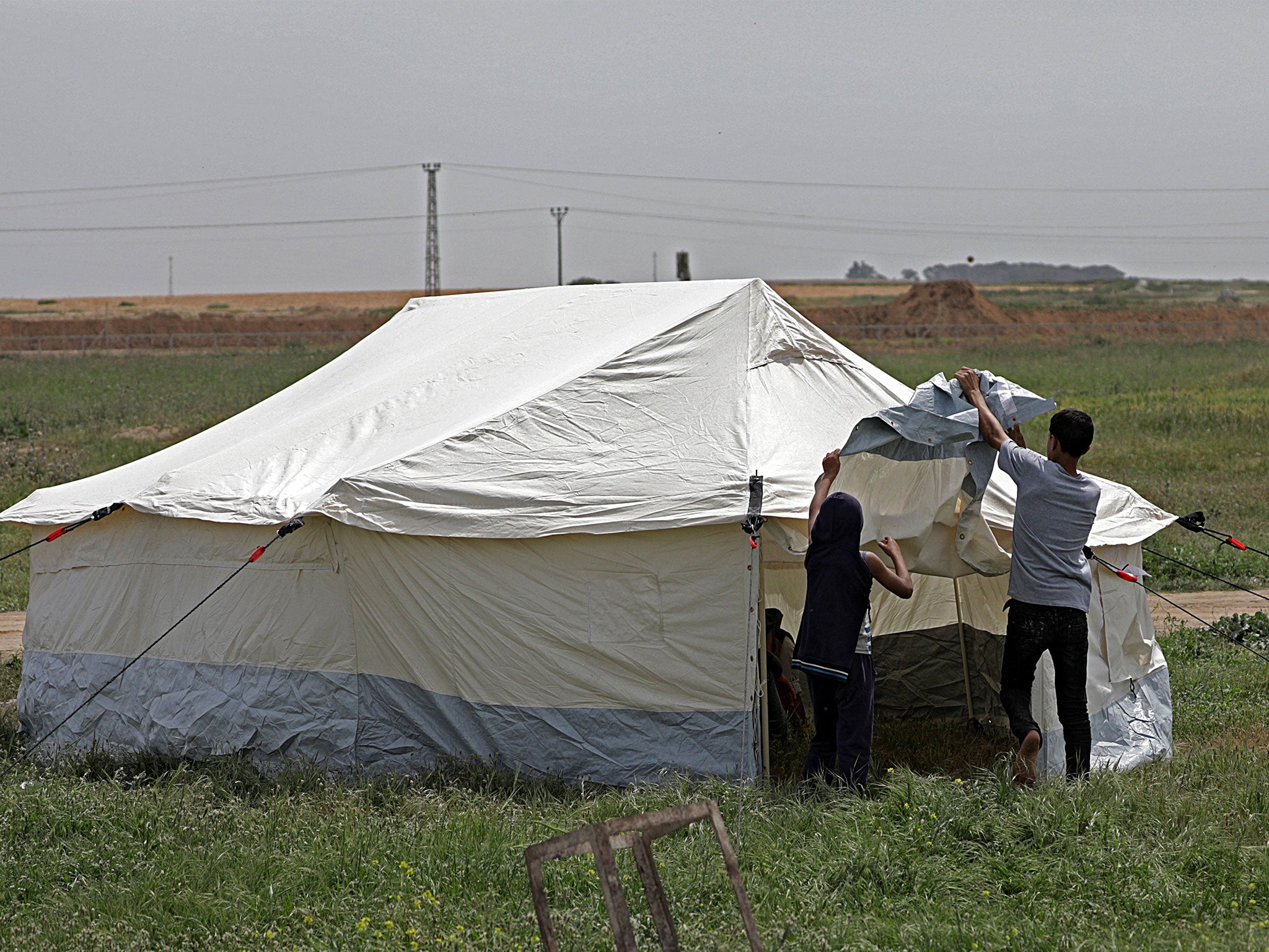 Palestinian youth prepare a tent during preparations for mass protests along the border between Israel and the Gaza Strip