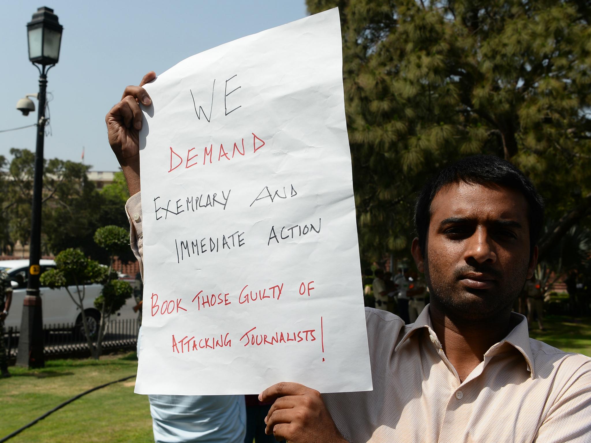 An Indian journalist holds a placard during a protest near the Indian parliament over the murder of journalists on 27 March 2018.