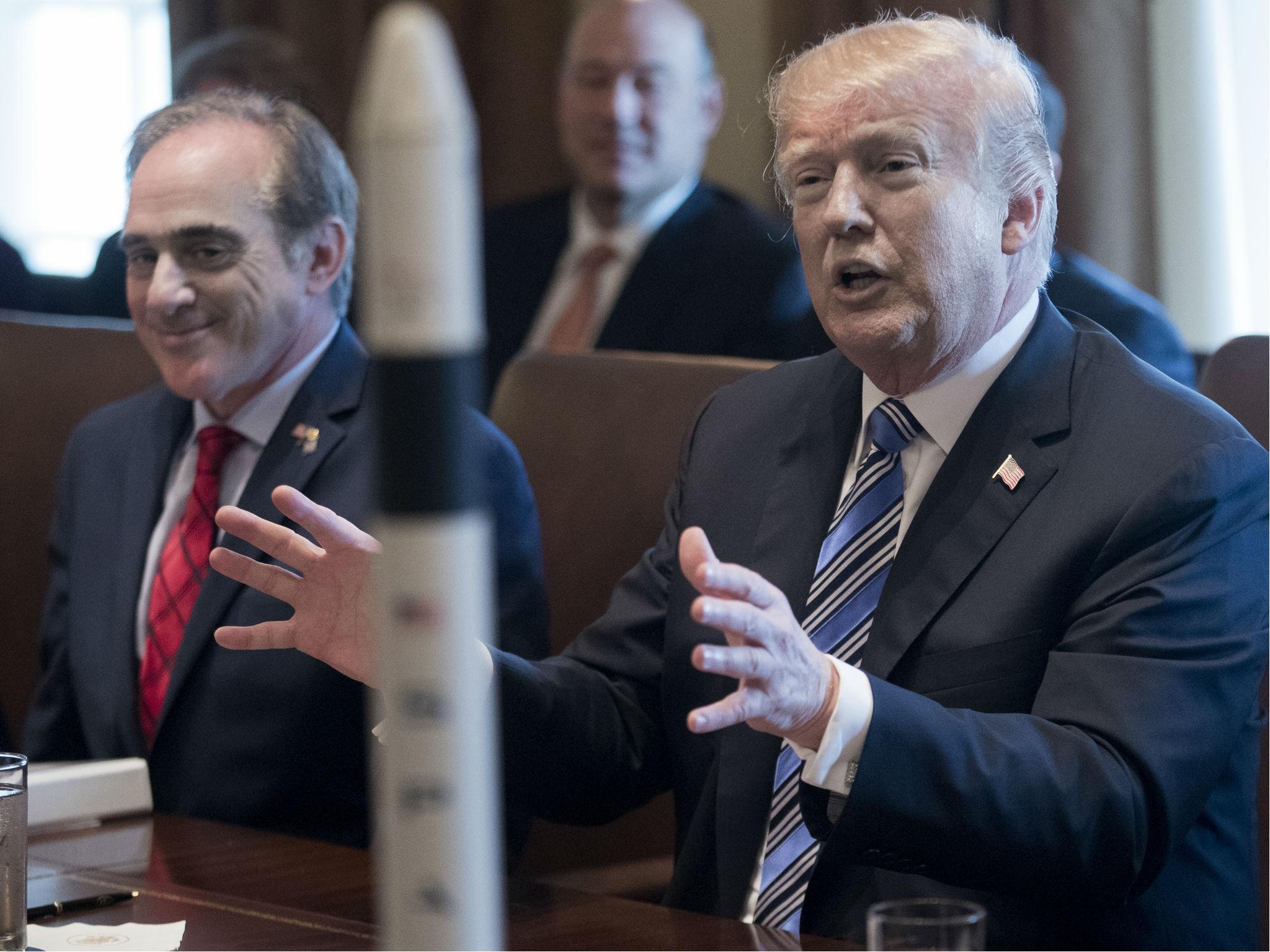 Mr Shulkin, at left, sitting next to the president during a cabinet meeting