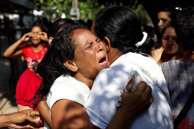 Relatives of inmates held at the General Command of the Carabobo Police react as they wait outside the prison