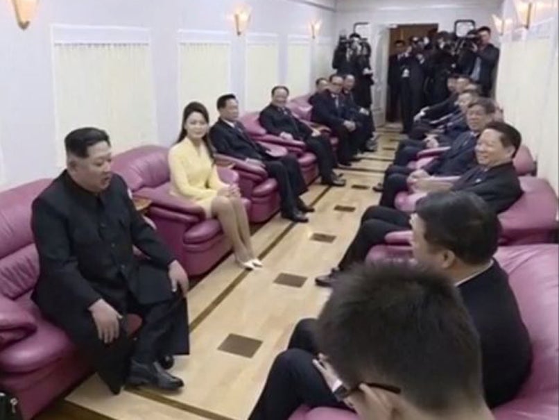North Korean leader Kim Jong Un meets with the head of the Chinese Communist Party’s international affairs department Song Tao as Kim’s wife Ri Sol Ju looks on, on a train in Dandong, China, in this still image from video released by KRT