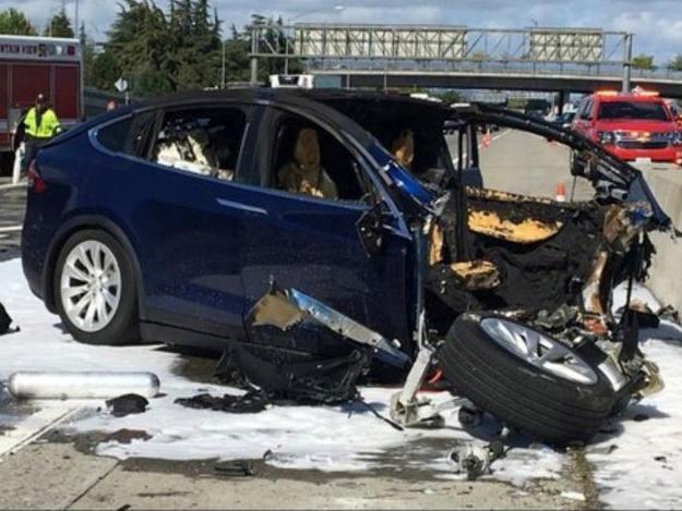 Emergency personnel work a the scene where the Tesla electric SUV crashed into a barrier on US Highway 101