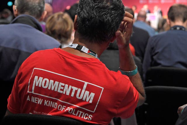 A member of the audience wearing a Momentum T-shirt listens to speeches at a Labour Party Conference