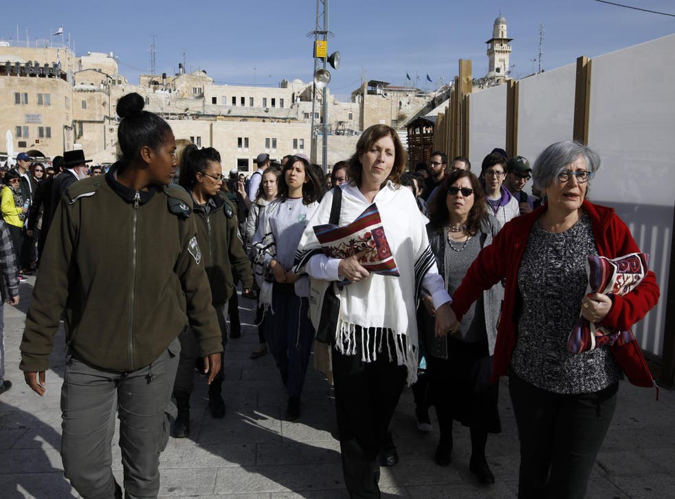Women of the Wall protesters are escorted by border police during a demonstration by ultra-Orthodox Jewish men against the group in Jerusalem's Old City, 27 February 2017