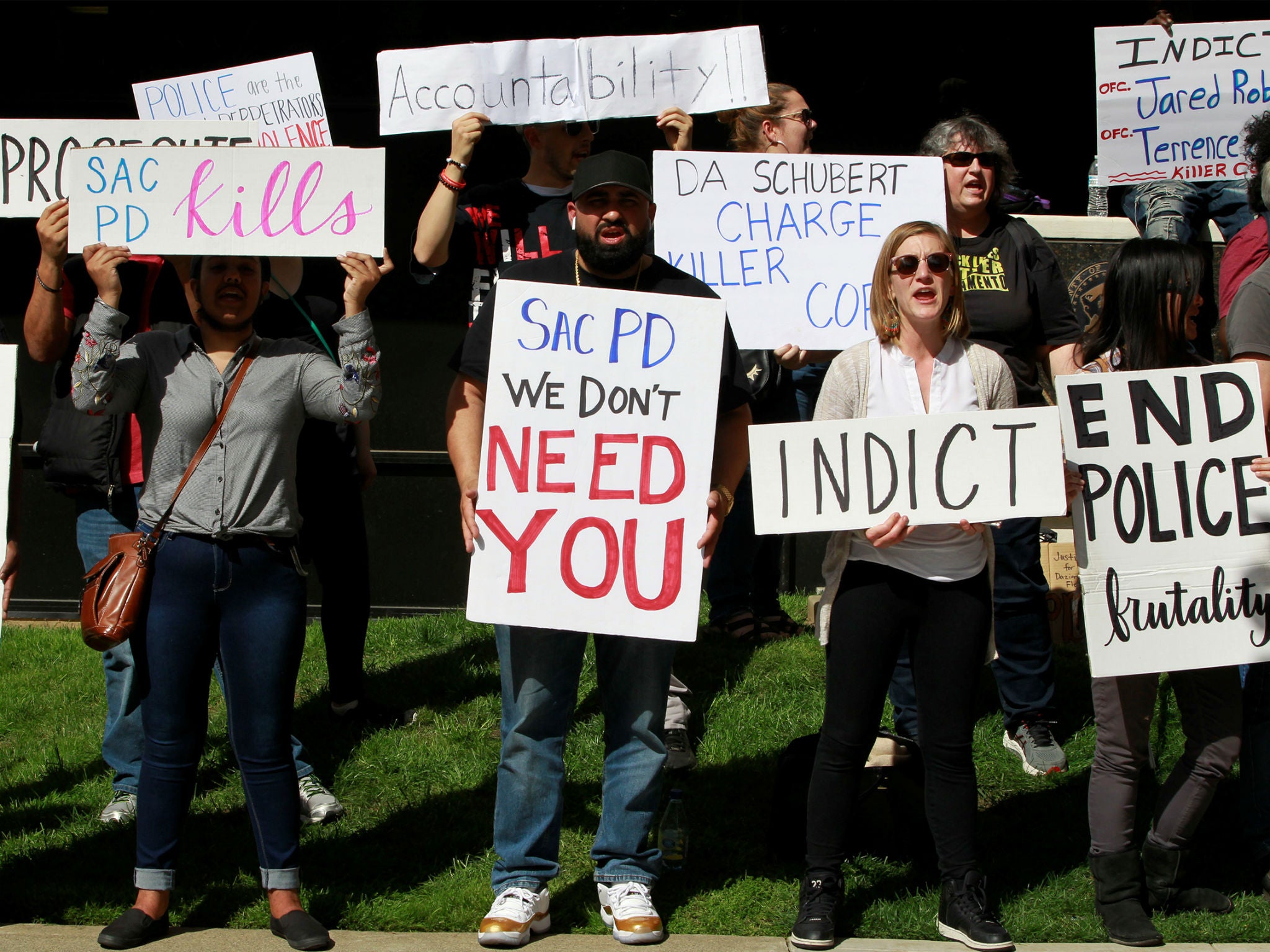 Protesters hold signs during a march downtown after the funeral of Stephon Clark, in Sacramento, California